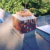 A residential flatroof. Chimney flashings are spliced and secured with both the masonry and the roof.